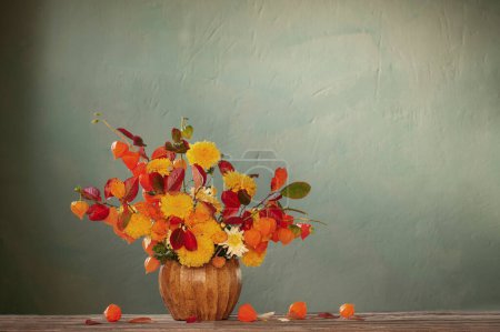 Photo for Beautiful autumnal  bouquet on wooden table on dark wall - Royalty Free Image