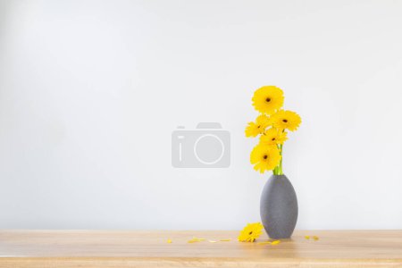Photo for Yellow gerbera in  vase on wooden shelf - Royalty Free Image