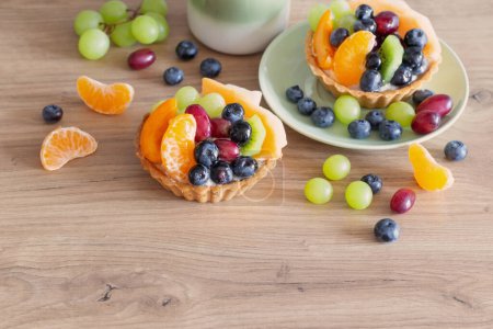 Photo for Cupcakes with fruits on wooden table on kitchen - Royalty Free Image