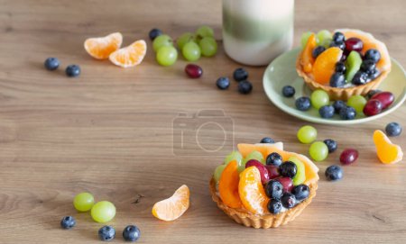 Foto de Magdalenas con frutas en la mesa de madera en la cocina - Imagen libre de derechos