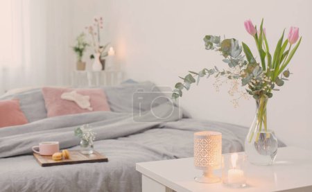 Photo for Interior of bedroom with flowers, candles and cup of tea - Royalty Free Image