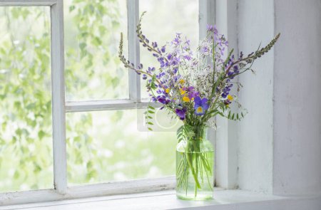 Foto de Flores silvestres en jarrón sobre alféizar de ventana blanco - Imagen libre de derechos