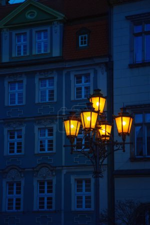 Téléchargez les photos : Lampadaire brille dans la rue de la ville la nuit - en image libre de droit