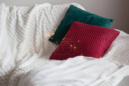 Photo for Red and green pillow on sofa with lights - Royalty Free Image