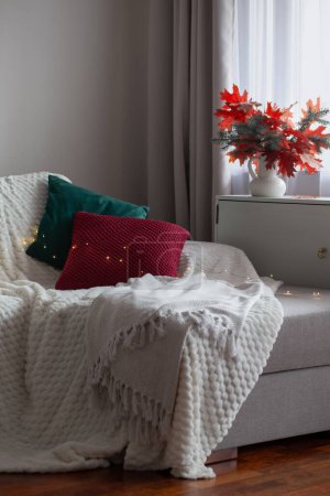 Téléchargez les photos : Chambre moderne blanche avec bouquet d'automne et oreillers sur canapé - en image libre de droit