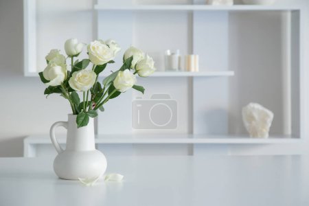 Téléchargez les photos : Roses blanches en cruche blanche à l'intérieur blanc - en image libre de droit