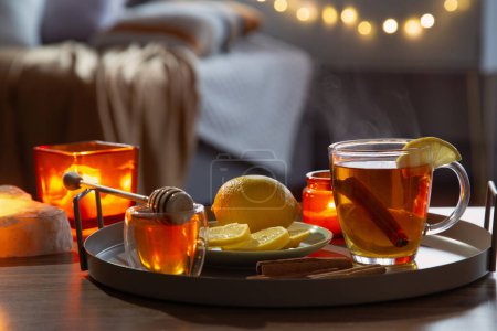 Foto de Taza de té con limón y miel en la mesa de madera en casa - Imagen libre de derechos