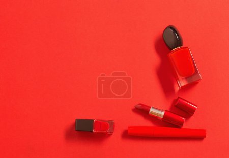 Foto de Frasco de perfume rojo y cosméticos sobre fondo rojo - Imagen libre de derechos