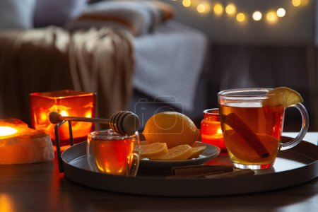 Téléchargez les photos : Tasse de thé au citron et miel sur une table en bois à la maison - en image libre de droit