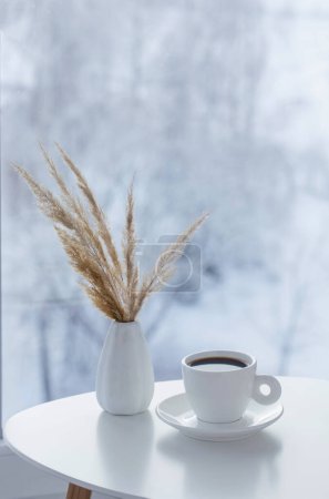 Foto de Taza de café en la mesa blanca por ventana en invierno - Imagen libre de derechos