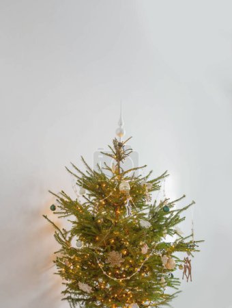 Téléchargez les photos : Arbre de Noël avec décor et lumières dans la chambre blanche - en image libre de droit