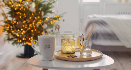 Téléchargez les photos : Tasse de thé blanc avec diffuseur sur plateau sur fond arbre de Noël dans la chambre - en image libre de droit