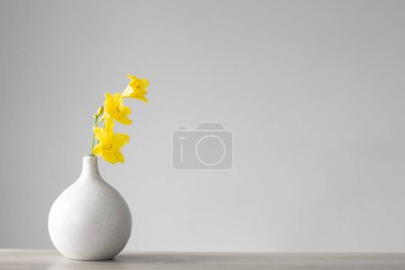 Téléchargez les photos : Fleurs jaunes d'été en vase blanc sur fond gris - en image libre de droit
