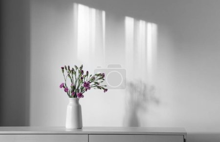 Foto de Flores de clavel en jarrón blanco en la pared de fondo - Imagen libre de derechos