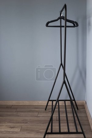 Photo for Empty black clothes hanger on gray wall background - Royalty Free Image