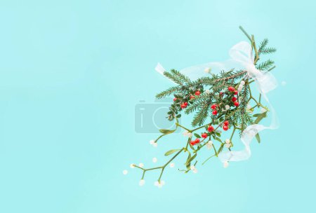 Téléchargez les photos : Fond de Noël avec gui et baies rouges sur fond vert - en image libre de droit