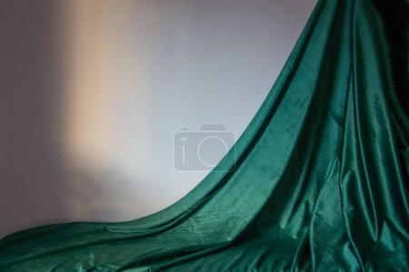 Foto de Cortina de terciopelo verde y pared gris a la luz del sol - Imagen libre de derechos