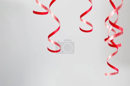 Photo for Red serpentine tape on background gray wall - Royalty Free Image