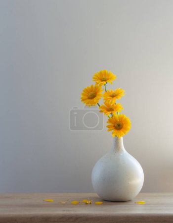 Photo for Yellow gerbera in modern  vase on wooden shelf - Royalty Free Image