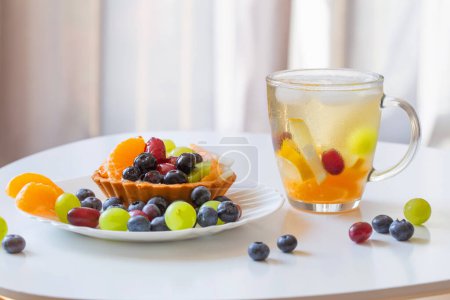 Foto de Magdalenas con frutas y bebida fría y saludable en la mesa blanca - Imagen libre de derechos