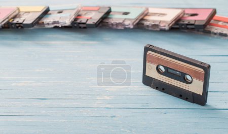 Téléchargez les photos : Vieille cassette en plastique sur fond de bois bleu. Concept de musique rétro - en image libre de droit
