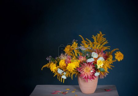 Foto de Flores amarillas y rojas en jarrón en estante vintage - Imagen libre de derechos