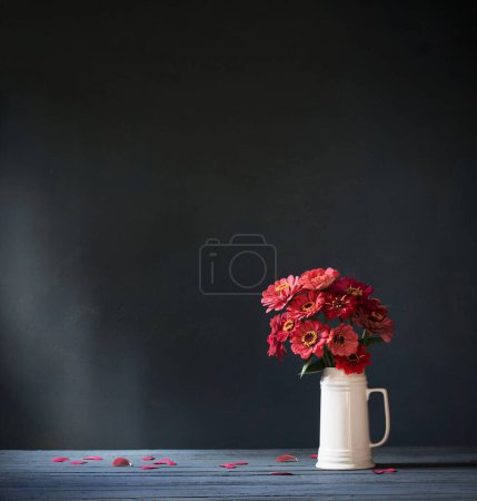 Photo for Pink flowers in white jug on dark blue background - Royalty Free Image