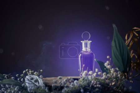 Foto de Poción mágica en botella de vidrio con plantas y flores sobre fondo púrpura - Imagen libre de derechos