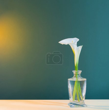 Téléchargez les photos : Belles fleurs blanches dans un vase en verre sur fond vert - en image libre de droit