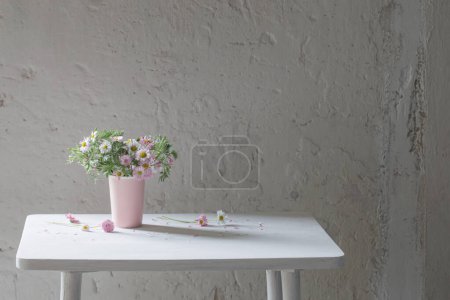 Foto de Flores de margarita en jarrón rosa sobre fondo blanco - Imagen libre de derechos