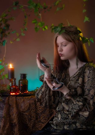 Téléchargez les photos : Jeune sorcière avec serpent et potions - en image libre de droit