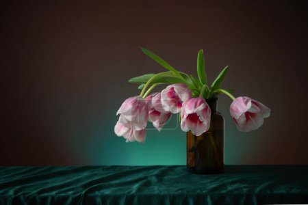 Foto de Tulipanes rosados en jarrón de cristal sobre fondo oscuro - Imagen libre de derechos