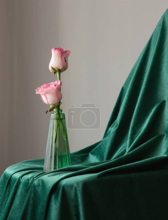Photo for Pink roses in green glass vase on background green velvet clothes - Royalty Free Image