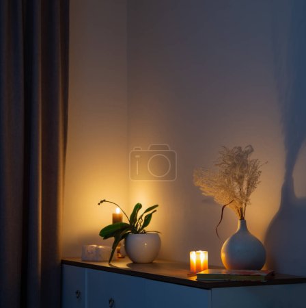 Téléchargez les photos : Bougies allumées avec des fleurs dans un vase dans la chambre la nuit - en image libre de droit