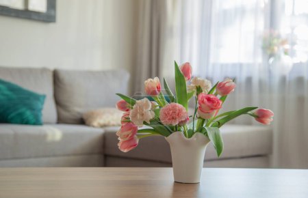 Téléchargez les photos : Fleurs de printemps roses en vase en céramique blanche à l'intérieur de la maison moderne - en image libre de droit