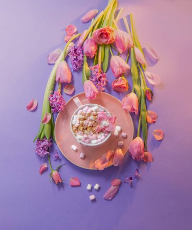 Photo for Pink cup of cocoa with marshmallow  with spring flowers on purple background - Royalty Free Image