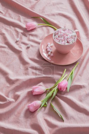 Téléchargez les photos : Fond rose avec tulipes et guimauves en tasse - en image libre de droit