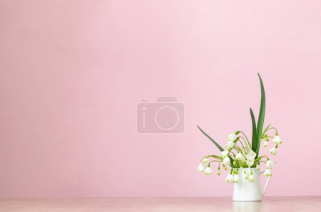 Photo for White spring flowers in jug on pink background - Royalty Free Image