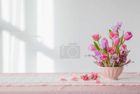 Foto de Flores de color rosa en jarrón sobre fondo pared blanca - Imagen libre de derechos