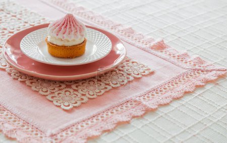 Photo for White and pink cupcake on plate on table - Royalty Free Image