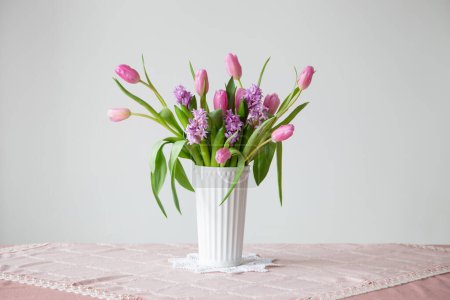 Téléchargez les photos : Fleurs de printemps en vase blanc dans un style vintage - en image libre de droit