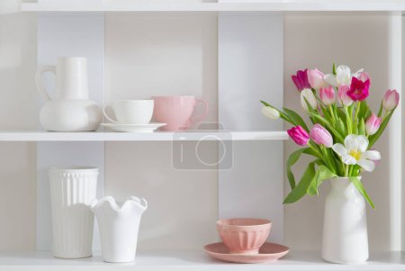 Téléchargez les photos : Tulipes en vase sur étagère blanche avec ustensiles de cuisine - en image libre de droit