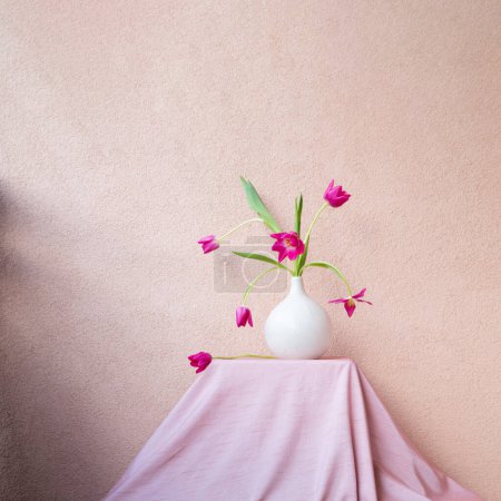 Foto de Tulipanes en jarrón en la mesa en la pared de fondo - Imagen libre de derechos