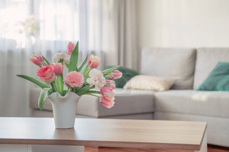 Téléchargez les photos : Fleurs de printemps roses en vase en céramique blanche à l'intérieur de la maison moderne - en image libre de droit