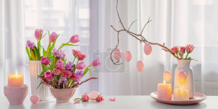 Téléchargez les photos : Décoration de Pâques à la maison avec des fleurs, des œufs, des bougies allumées - en image libre de droit