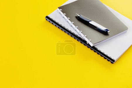 Foto de Concepto de negocio con cuadernos y bolígrafo sobre fondo amarillo - Imagen libre de derechos