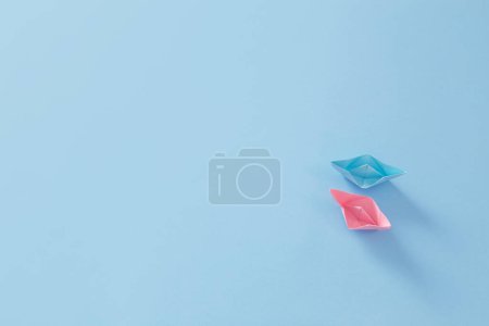Téléchargez les photos : Bateaux en papier rose et bleu sur fond bleu - en image libre de droit