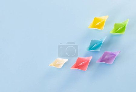 Photo for Color paper boats on blue background - Royalty Free Image