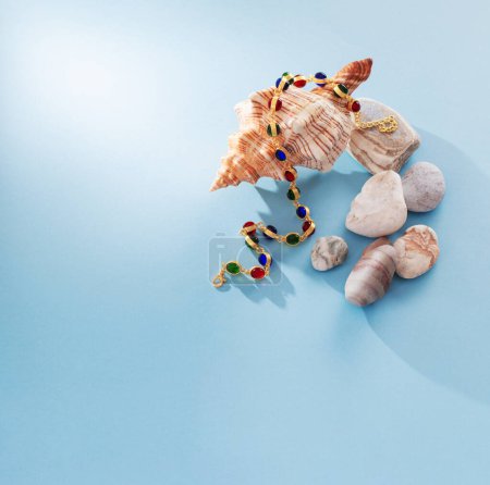 Foto de Joyas modernas con piedras y concha sobre fondo azul - Imagen libre de derechos