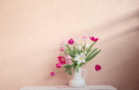 Foto de Tulipanes en jarrón en la mesa en la pared de fondo - Imagen libre de derechos